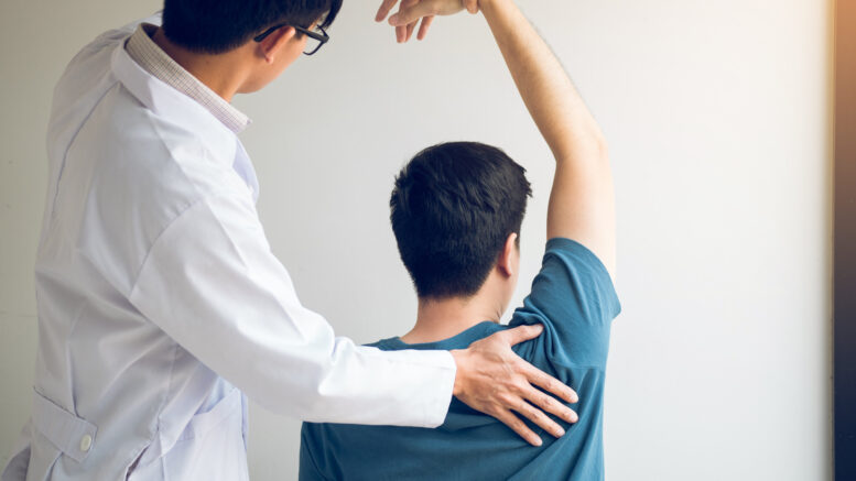 Chiropractor Stretching a Young Man's Arm